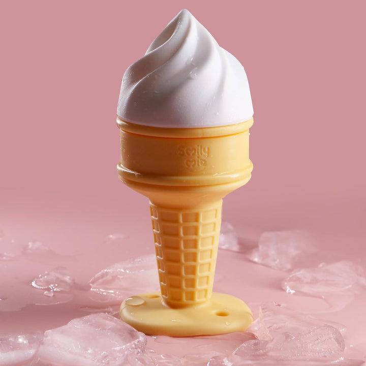 Smily Mia white vanilla soft serve ice cream cooling teether surrounded by melting ice cubes on pink background showing freezable water-filled design for baby teething relief