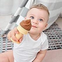 Smiling baby boy holding up Smily Mia ice cream shaped silicone teether toy