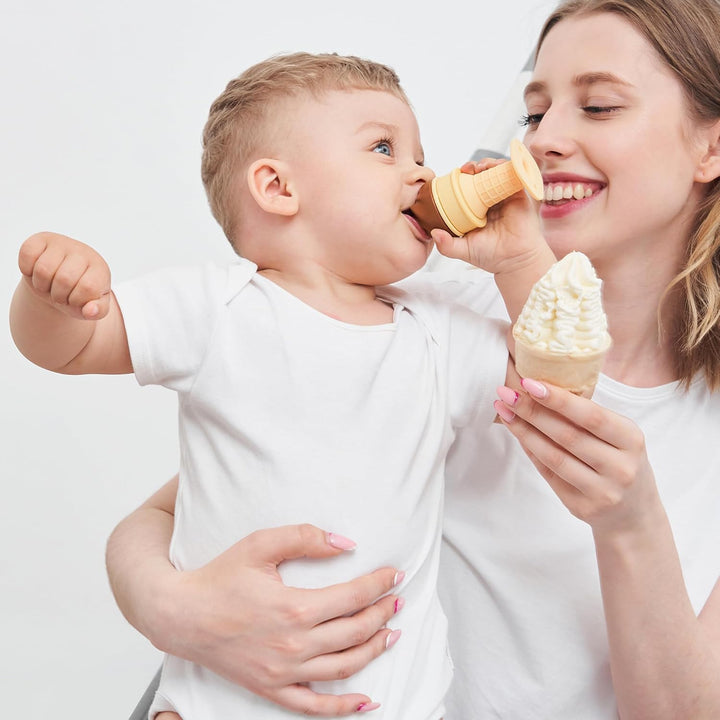 Mother holding baby who is chewing Smily Mia ice cream cone teether while mother holds a real ice cream cone showing matching ice cream theme