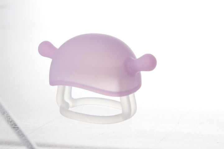 Smily Mia Little Mushroom Teething Mitten in purple color showing soft silicone mushroom cap with ear-like nubs and clear wrist ring base designed for 0–6 month babies