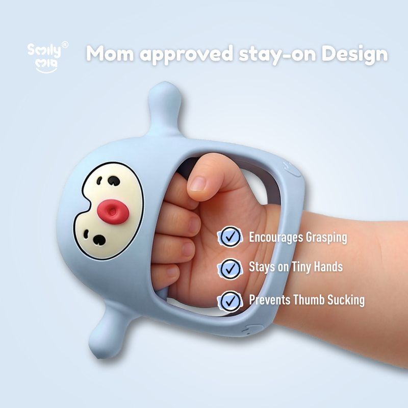 Baby hand holding a blue toy with a cartoon face, labeled 'Mom approved stay-on design'.